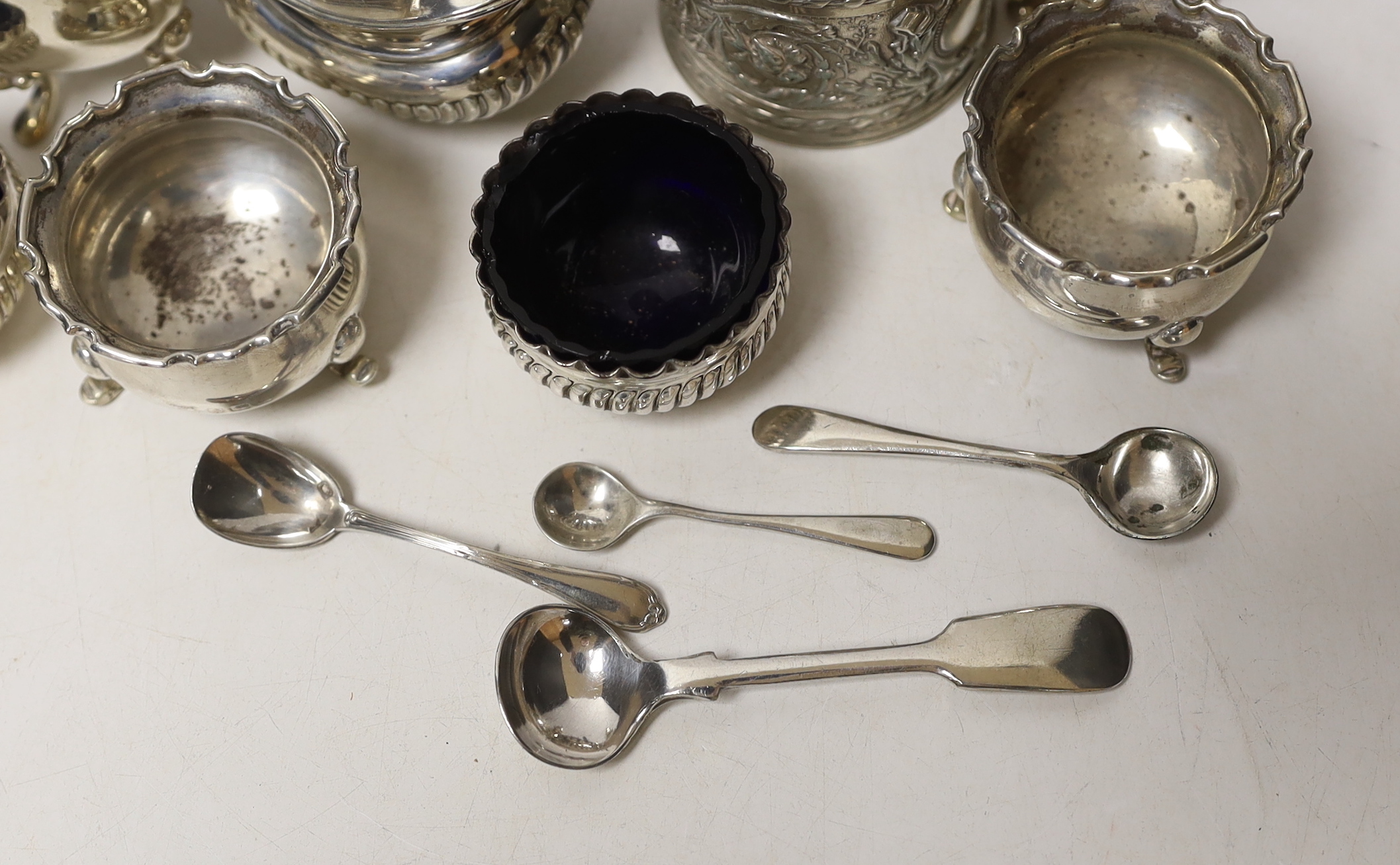 Two pairs of small silver salts, a pair of silver pepperettes, and two silver mustard pots including late Victorian, together with five small spoons (one silver).